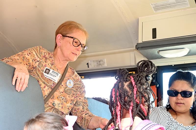 Debra Groff, a CFISD Bus Buddies volunteer, helps Hairgrove Elementary School students onto their bus on Aug. 28. 